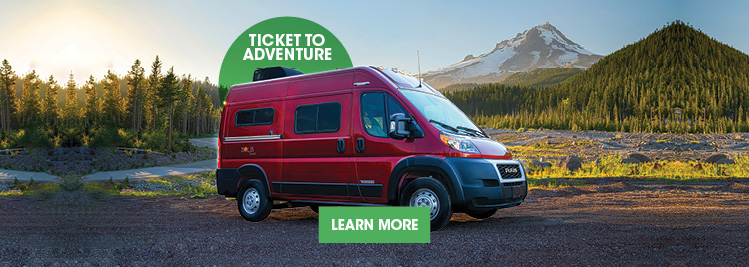 Red Winnebago Solis Pocket parked in picturesque mountainscape.